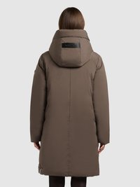 Puhani smeđi kaput s velikim kapuljačom, označenom zakrpom na leđima i bočnim patentnim zatvaračima. Ima ravan kroj i glatku, mekanu teksturu.