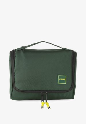 Bolso de viaje verde oscuro hecho de tela texturizada, con un bolsillo frontal con acentos amarillos, doble cremallera y un asa superior para llevar.