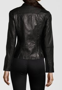 Sort læderjakke med tætsiddende design, ribbede skulderdetaljer og lodrette søm. Glat tekstur, lange ærmer.