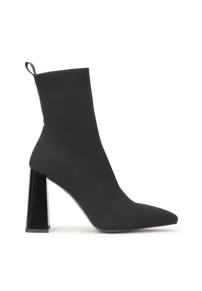 Black sock-style high heel boot with pointed toe and a transparent block heel. Features a ribbed top and smooth fabric texture.