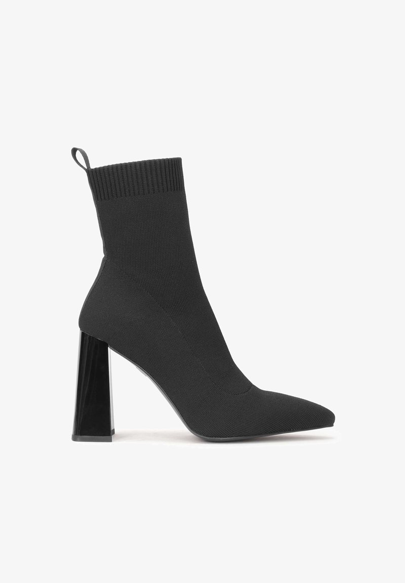 Black sock-style high heel boot with pointed toe and a transparent block heel. Features a ribbed top and smooth fabric texture.