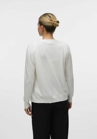 Maglione bianco a maglia con scollatura rotonda, maniche lunghe e orlo aderente, caratterizzato da una texture liscia e decorazioni minime.