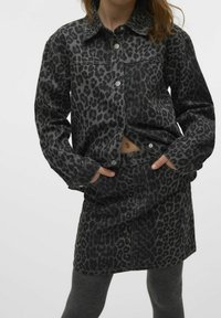 Črna jeans jakna z sivo leopardjim vzorcem, z sprednjim gumbom za zapiranje in dvema stranskima žepoma, v kompletu z ujemajočo se črno jeans krilom.