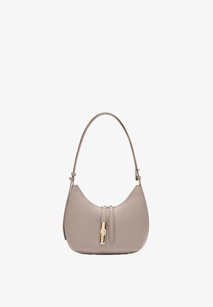 Borsa a tracolla in pelle color taupe chiaro con una singola tracolla e dettagli di cerniera tono oro sul davanti su un corpo curvo.