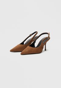 Pantofi cu toc maro din piele întoarsă, cu vârf ascuțit și toc subțire, înalt. Au o curea reglabilă la gleznă și o căptușeală interioară netedă, neagră.