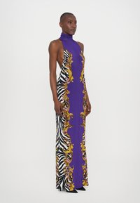 Lila Kleid mit hohem Kragen, das an den Seiten ein Blumen- und Zebra-Streifen-Muster aufweist, gefertigt aus einem glatten, dehnbaren Material.