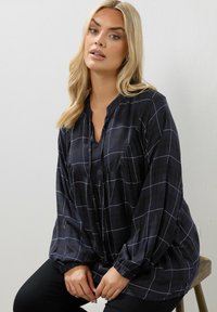 Blusa a scacchi blu navy con una vestibilità rilassata, dotata di colletto a contrasto, maniche lunghe a palloncino e dettaglio frontale arricciato.