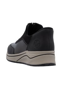Chaussure noire à enfiler avec une tige en cuir, panneau latéral élastique, col rembourré et semelle en caoutchouc présentant un design blanc incurvé et un détail de logo.