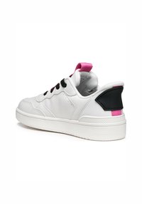 Weißer Sneaker mit schwarzen Schnürsenkeln, pinker Fersenschlaufe und schwarzem Akzent auf der Rückseite. Aus glattem, lederähnlichem Material und mit strukturiertem Sohlen.