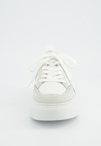 White sneaker with a smooth leather upper and suede accents, round toe, thick white sole, and flat laces. Silver detailing near the toe.