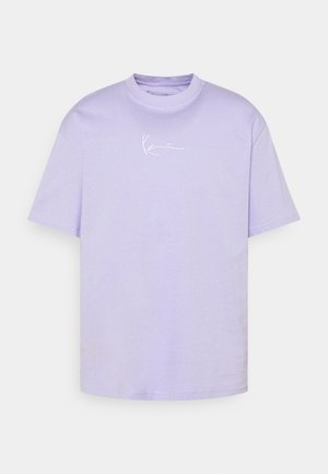 Camiseta de manga corta lila con cuello redondo y pequeño logotipo blanco en cursiva centrado en el pecho sobre un fondo blanco.