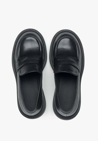 Zwarte instap schoenen met een gladde leren afwerking, ronde vorm, brede band over de wreef en een gestructureerde rubberen zool.