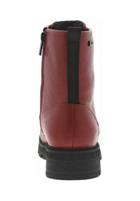 Bottine en cuir rouge avec une finition texturée, fermeture éclair sur le côté, accent en élastique noir, et une semelle en caoutchouc noir robuste.