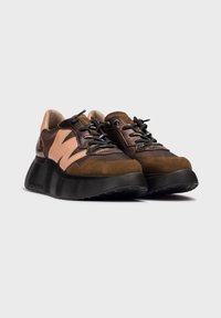 Sneaker marroni e beige con pannelli in suede e rete testurizzati, lacci neri e una suola nera spessa e rigata, caratterizzata da un design prominente.