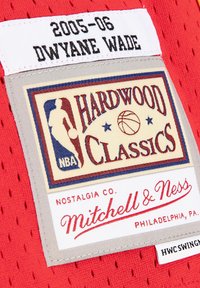 Roter Netzstoffanhänger mit dem Text "2005-06 Dwyane Wade". Das Logo in Creme, Rot und Blau trägt den Schriftzug "Hardwood Classics", mit "Mitchell & Ness" darunter.