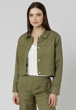 Veste olive verte courte en matériau léger, dotée d'un col pointu, d'une fermeture à boutons sur le devant et de deux poches poitrine. Texture lisse.
