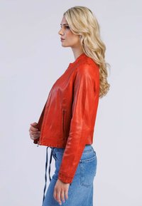 Röd läderjacka med dragkedja fram, två sidofickor och en kort design. Den släta texturen och minimala sömnadsdetaljer förbättrar utseendet.