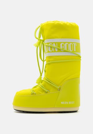 Jasnożółty Moon Boot wykonany z wytrzymałego materiału, z ściąganym czubkiem, dekoracyjnymi frędzlami i grubą podeszwą dla wsparcia.