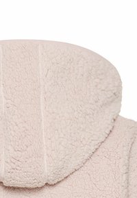 Roze fleece hoodie heeft een zachte, gestructureerde oppervlakte met een ronde capuchon en stikseldetails aan de voorkant.