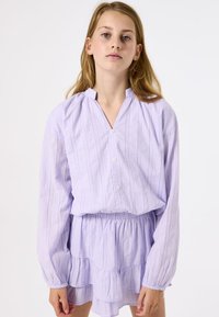Licht lila jurk met knoopsluiting, lange mouwen en een gegatherde gelaagde rok, met verticale streepjes en een zachte textuur.