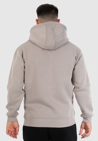 Grijze hoodie van lichte stof, met ribgebreide manchetten en onderste zoom, een ruime capuchon en een gladde textuur. Achteraanzicht, zonder grafische elementen.