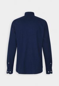 Námořnické modré tričko s dlouhým rukávem, klasickým límcem, knoflíkovými manžetami a hladkou texturou; má jednobarevný design bez vzorů.