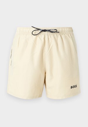 Short de bain beige pour homme avec taille élastique, cordon noir, poches latérales et logo "BOSS" sur la jambe gauche.