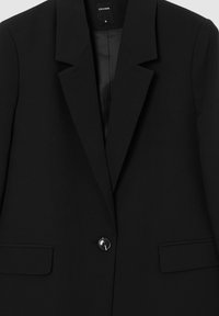 Blazer nero con revers a punta, chiusura a un bottone, due tasche frontali e texture in stoffa liscia. L'etichetta indica la taglia S.