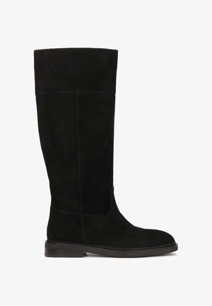 Mustat mokkasaapikkaat polven korkeudella, joissa on pyöreä kärki ja minimaalinen ompelu. Littee pohja, jossa on kevyt korko, sileä pinta kauttaaltaan.