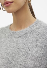 Light gray knitted sweater with a round neckline. Soft texture with a slightly fluffy finish and ribbed edges near the neckline.