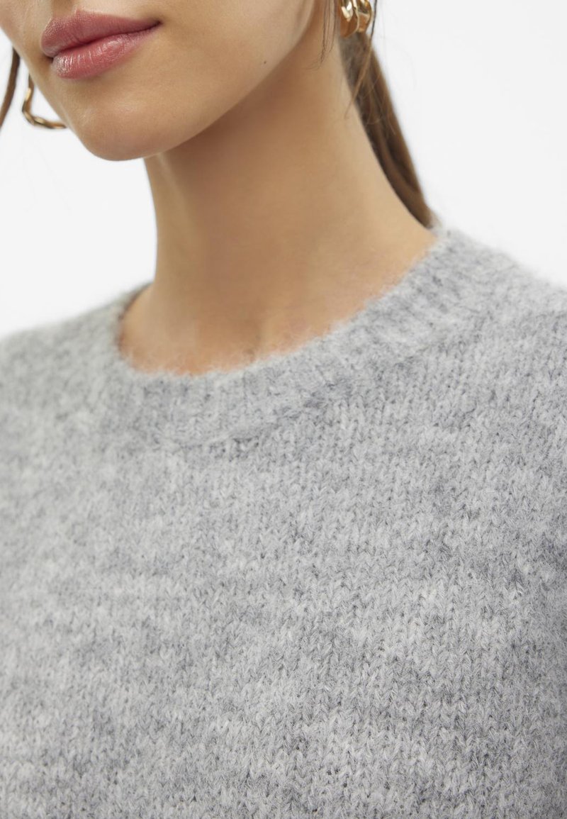 Hellgrauer Strickpullover mit Rundhalsausschnitt. Weiche Textur mit einem leicht flauschigen Finish und gerippten Abschlüssen am Halsausschnitt.