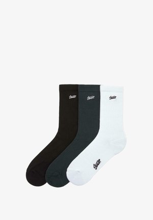 Drei Paar gerippte Socken in Schwarz, Dunkelgrün und Weiß, mit einem kleinen Logo an jedem Kragen. Weicher, dehnbarer Stoff.