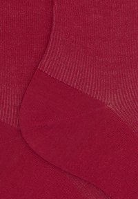 Calze rosse con una texture a coste e pannelli lisci. Il colore è uniforme, mostrando una tonalità audace e intensa.