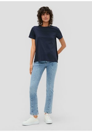 Navyblauwe katoenen T-shirt met korte mouwen, gecombineerd met lichtblauwe jeans en witte sneakers. Eenvoudig, relaxed fit ontwerp zonder patronen.