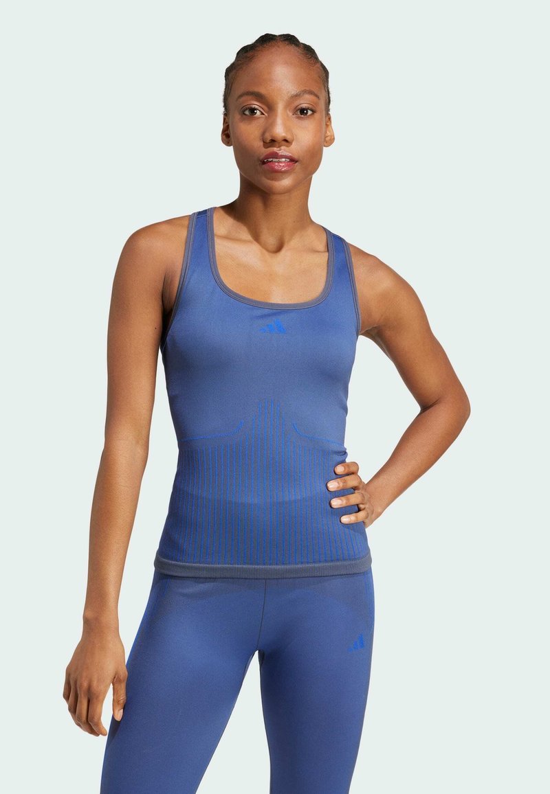 Camiseta de deporte azul de corte ajustado, con rayas verticales, escote redondo y el logo de Adidas en el pecho.