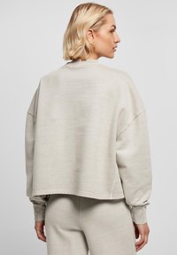 Lys grå, kort sweatshirt med en avslappet passform, ribbede mansjetter og myk tekstur, med drop-skuldersømmer og et enkelt design.