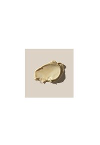 Substance beige crémeux avec une texture lisse, étalée en une forme épaisse et irrégulière sur un fond clair.