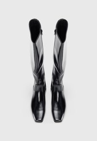 Botas de cuero negras hasta la rodilla con punta cuadrada, textura suave y cierre de cremallera en el lateral. Diseño elegante y ajustado sin adornos.
