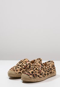 Luipaardprint espadrilles met een textiele bovenkant, ronde neus en contrasterende jute touwenzool, voorzien van decoratieve veters en stiksels.