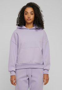 Sweatshirt à capuche en coton lavande avec une poche frontale, des poignets et un ourlet côtelés ; coupe décontractée et texture douce pour le confort.