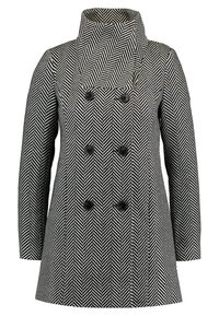 Černobíle vzorovaný kabát v rybí kost s dvojitým zapínáním, šesti černými knoflíky a širokým, vysokým límcem.