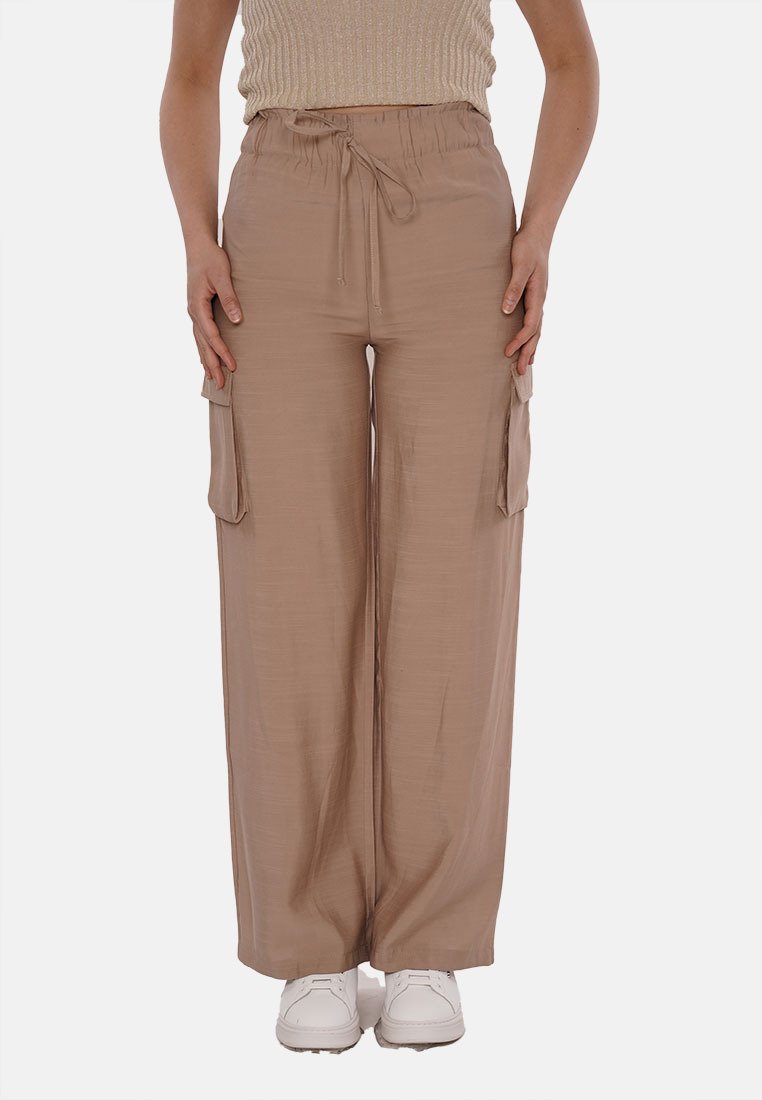 Pantaloni cargo beige a gamba larga con fascia in vita elastica e coulisse regolabile. Presenta due tasche laterali. Realizzati in un tessuto leggero.