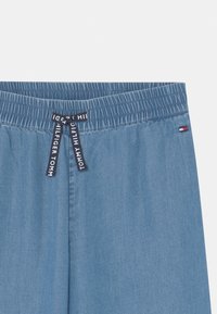 Niebieskie szorty dżinsowe z elastycznym paskiem, z kontrastowym sznurkiem dopasowującym z logo "TOMMY HILFIGER" oraz małą metką z logo.