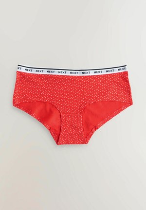 Röda bomullsboxer med vita prickar och en elastisk midjeband i svart och vitt med texten "NEXT". Slät textur och medelhöjd design.