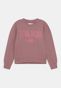 Sudadera de color rosa polvo, hecha de tela suave. Cuenta con "REVOLUCIÓN" en bordado rosa en el pecho y un dobladillo corto.