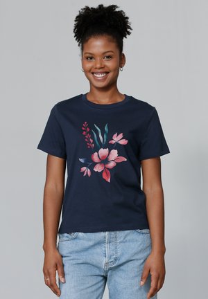 T-shirt en coton navy avec un imprimé floral dans des nuances de rose et de teal, avec un col rond classique et des manches courtes. Coupe décontractée.