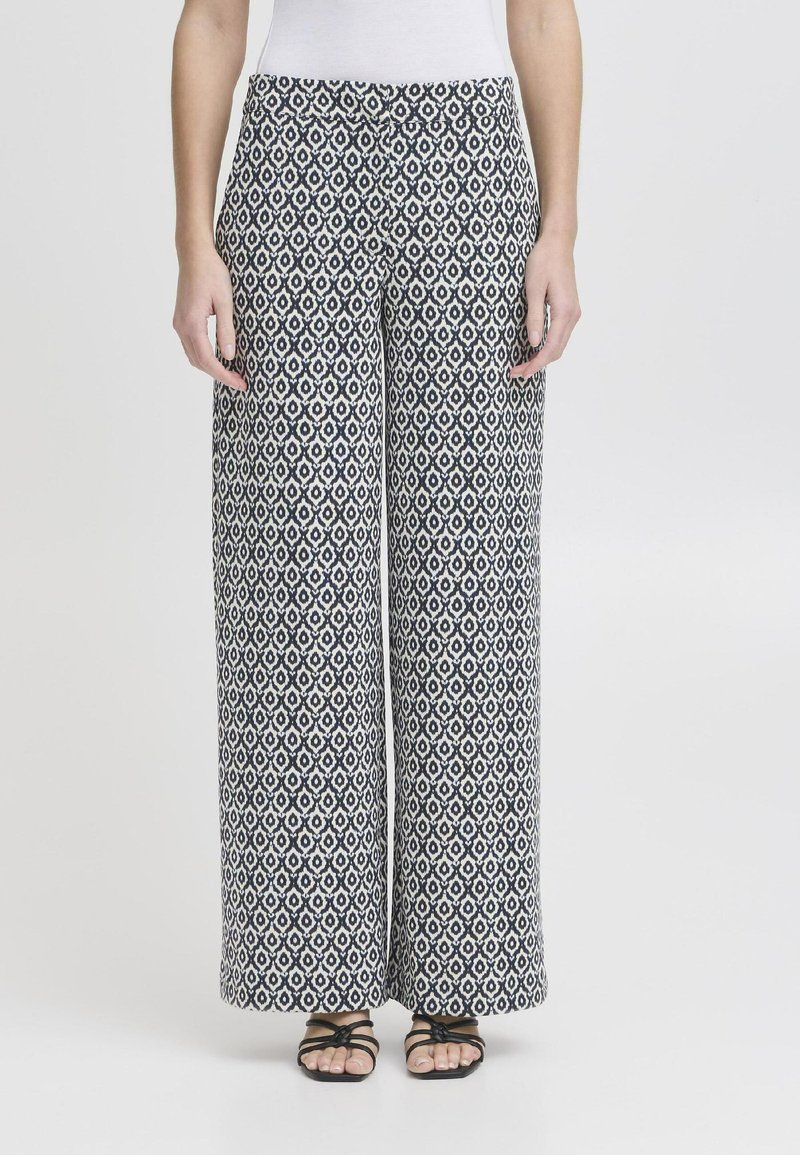Pantalons large en tissu à motifs bleu marine et blanc, avec un design géométrique. Matériau léger avec une texture fluide.