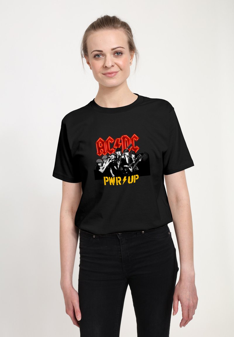 Czarna bawełniana koszulka z wyrazistym nadrukiem graficznym, na którym znajduje się napis "AC/DC" na czerwono oraz "PWR UP" na żółto, a także monochromatyczny obraz zespołu.