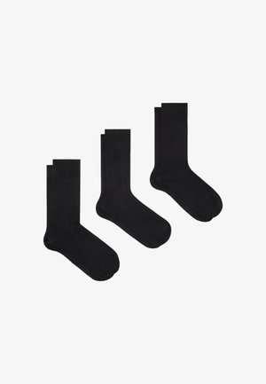 Set di calzini neri che include tre paia: due con texture a costine e uno liscio. Tutti presentano un design semplice e classico con lunghezza fino al polpaccio.