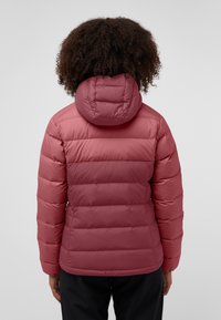 Veste en duvet rouge avec une texture matelassée, une capuche ajustée et des poignets élastiques. Le design présente des coutures horizontales et une surface lisse.